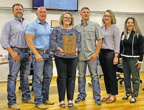 KRISTINE BRISCO, CENTER, received a plaque in appreciation of her years of service as a member of the Snook ISD School Board during Monday night’s board meeting. Pictured with Brisco, from left, are Cameron Schluens, Justin Hruska, Bradley Prihoda, Tiffany Sodolak and Dr. Megan Pape, Snook ISD Superintendent. -- Tribune photo by Denise Squier