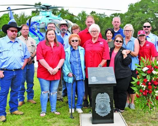 THE SMITH FAMILY, INCLUDING Barbara Smith, Debbie Colley and members of the Deanville Volunteer Fire Department gather around the monument. Also joining them are Paul Luckey of Rockdale Monuments, Wallace Jones, owner of Phillips &amp; Luckey Funeral Home, and Marci Ramirez of Phillips &amp; Luckey Funeral Home.