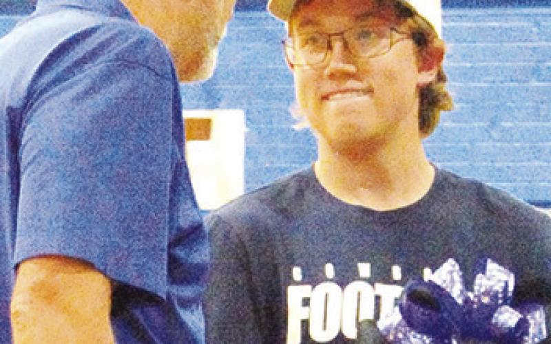 SNOOK HIGH SCHOOL Principal Lee Hafley talks to Snook senior William See during a cake auction to raise money for the athletic booster club at last week’s “Meet the Bluejays.”