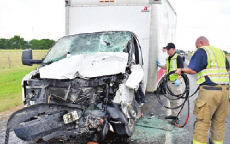 FIREFIGHTERS RESPOND TO the scene of this June 21 accident on State Highway 21 East near CR 208. -- Tribune photo by Roy Sanders