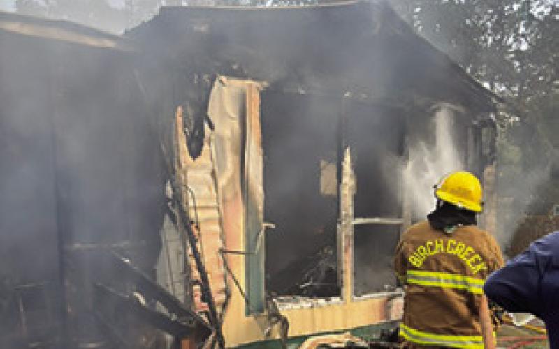 A BIRCH CREEK firefighter battles this house fire last Friday at Shady Oaks Drive at Somerville Place Subdivision. Photo courtesy of Birch Creek VFD.