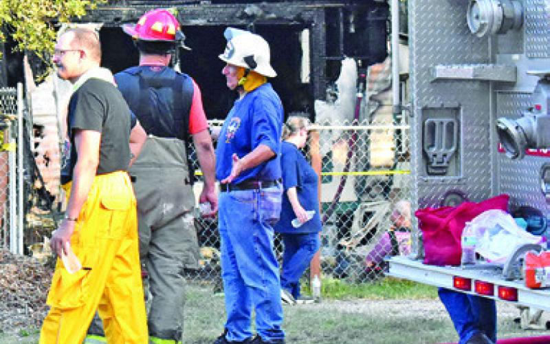 FIREFIGHTERS WORK THE scene of this singlewide house fire on Friday, July 24, at Somerville Place Subdivision. Tribune photo by Roy Sanders