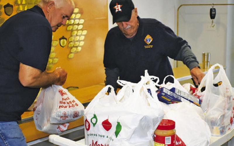 EDWARD MUZNY AND Ken Bartnesky work on Wednesday, Dec. 3, at the Food for Families Food Drive at St. Mary’s Catholic Church.