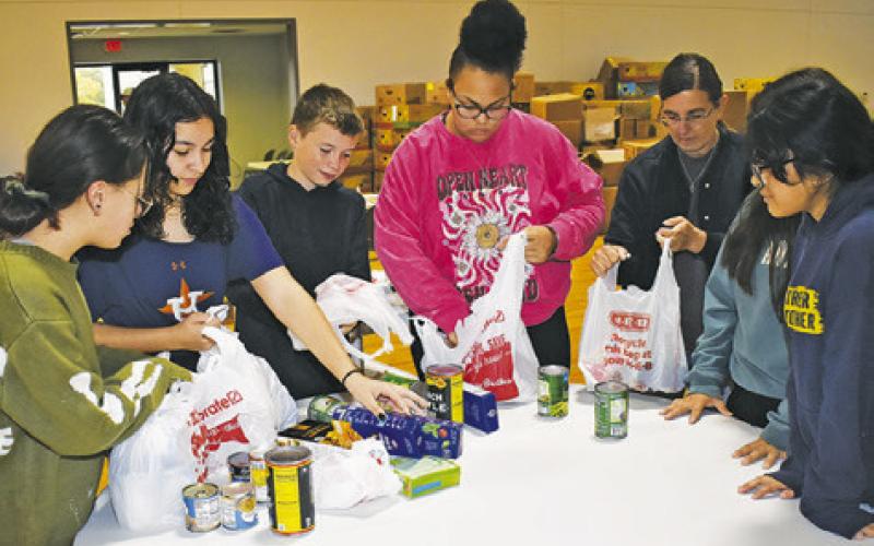 CALDWELL JUNIOR HIGH students help on Wednesday, Dec. 4, at the Food for Families Food Drive at St. Mary’s Catholic Church.