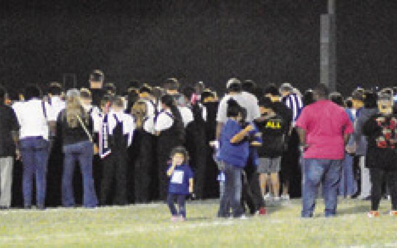 FANS, PLAYERS AND COACHES come onto the field to pray for Bartlett’s Frankie Gonzales. Gonzales was injured during the game and transported by ambulance to an area hospital.