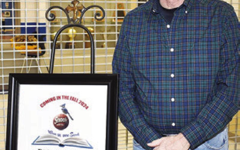 AUTHOR JOHN COUSSONS displays this exhibit promoting his upcoming book on Snook Bluejays basketball history.