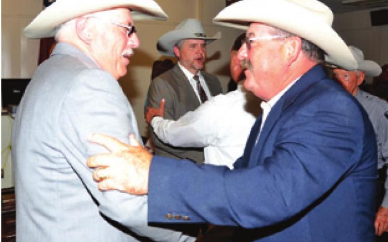 NEW BURLESON COUNTY Sheriff Gene Hermes is congratulated by Retired Chief Deputy Mike Brackman after the swearing in ceremony at the courthouse. -- Tribune photo by Roy Sanders