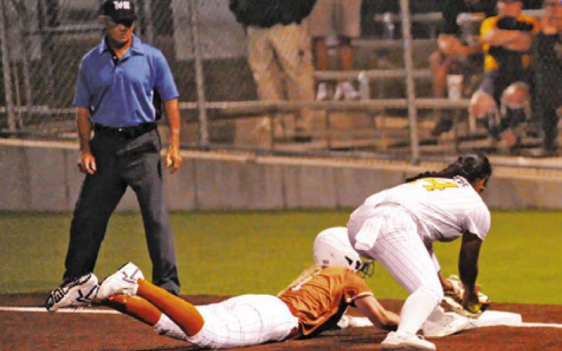 CALDWELL’S MIA WITHERWAX gets safely back to first base during the Caldwell-Sealy bi-district game last Thursday night. Tribune photo by Denise Squier