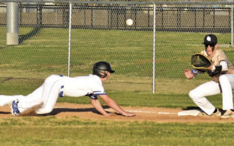 SNOOK’S BONHAM BOSLEY DIVES back to first base as the ball approaches. Tribune photo by Roy Sanders