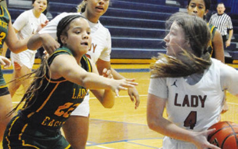 CALDWELL’S CADIE COSTON tries to keep the ball away from Lexington’s Nyla Green during their game at the Snook Lady Jay Basketball Tournament on Friday. -- Tribune photo by Denise Squier