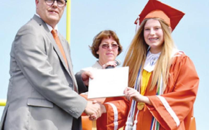 CAYLEE HERMES receives her diploma by CISD Superintendent Andrew Peters.