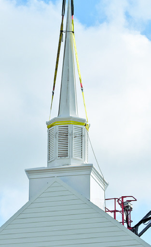 THE NEW STEEPLE is put in place at New Tabor Brethren Church last Wednesday. Tribune photo by Roy Sanders