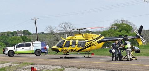 MEDICS GET THE stretcher out of the helicopter and head to the accident scene on State Highway 21. -- Tribune photo by Roy Sanders