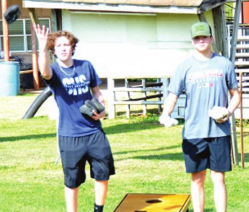 HUNTER PETTY AND Tyland Lackey play cornhole on Saturday for Project Graduation at the county fairgrounds.