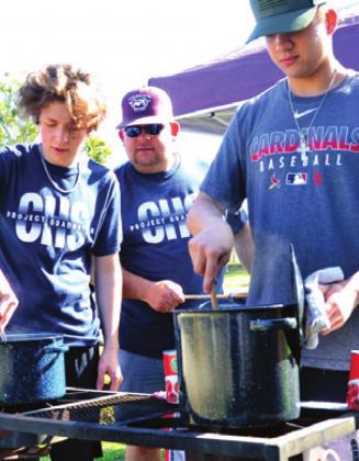 HUNTER PETTY, MARSHALL PETTY and Tyland Lackey stir this chili on Saturday at the cookoff for Project Graduation.