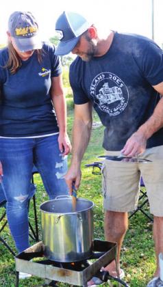 THIS TEAM CONSISTING of Grant and Jill Becka and Jared Sikorski stir their chili during the Project Graduation cookoff.