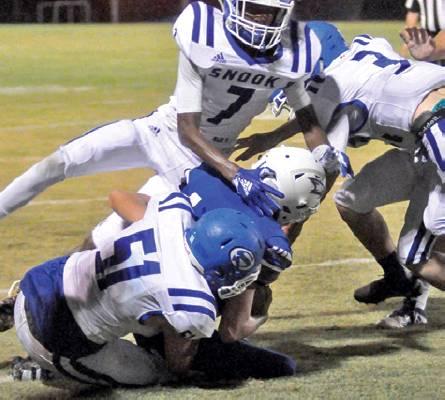 DESHUN HAMILTON, DAVID Davis and Justin Supak move in for this tackle last Friday against Brazos Christian School in Bryan. Snook lost 48-38. -- Tribune photo by Roy Sanders