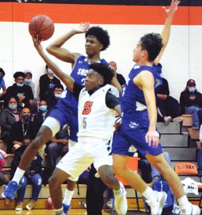 SOMERVILLE’S VERKOBE WOODBERRY shoots with Snook’s Jermaine Kearney and David Davila defending during the Yegua-Bluejay game last Tuesday night. -- Tribune photo by Denise Squier