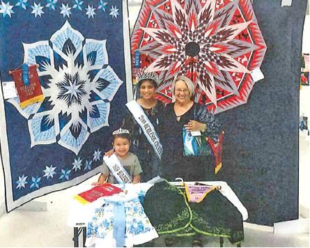 PEACHIE BURLIN WON grand champion in adult small quilt, children’s wear, professional-purse and quilt. She is joined by Fair Queen Jessica Enrique and Little Miss Karlee Praesel.