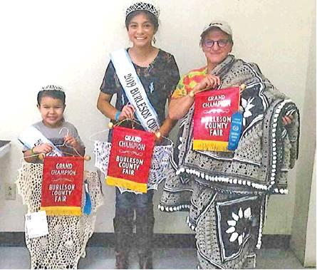 SONJA TURNER WON grand champion in adult crafts, crochet and Afghan. She is joined by Fair Queen Jessica Enrique and Little Miss Karlee Praesel.