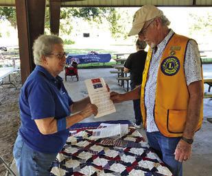 BARBARA BEHLER MANNING promotes the Quilts of Valor at the National Night Out at the Snook City Park. Photo courtesy of Barbara Behler Manning