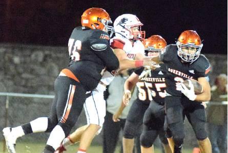 SOMERVILLE’S JEREMIAH TEAGUE runs through the offensive line while lineman Cedric Hudgen blocks a Burton defensive player. Burton won Friday night’s Somerville Homecoming game at The Rock. -- Tribune photo by Denise Hornaday