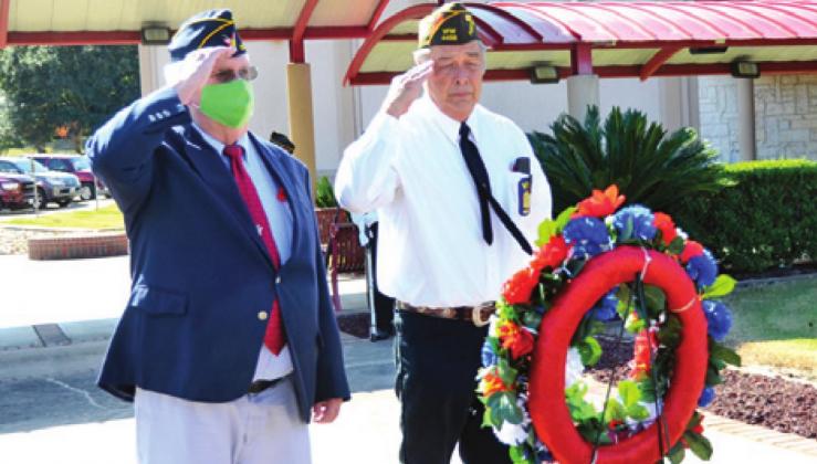DONNY WOOD OF the Caldwell American Legion Post and Tommy Miles of the Caldwell VFW Post salute at the Veterans Memorial at the Caldwell Civic Center. -- Tribune photo by Roy Sanders