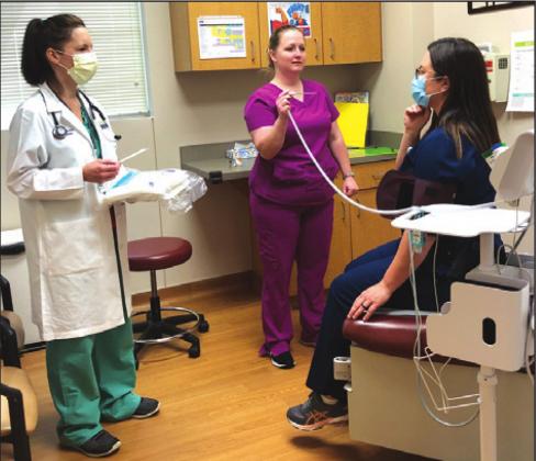 BURLESON COUNTY HEALTH OFFICER, Dr. Kristel D. Leubner, D.O., stands by as Krystal Stuart, CMA, and Kim Glidewell M.S, P.A.C, review clinic protocols during the COVID-19 virus threat.