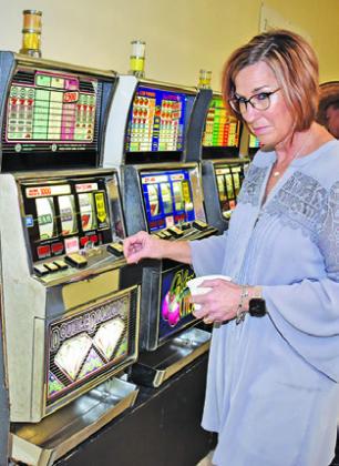 MELISSA BRUNE enjoys the slot machines at the Caldwell Rotary Club Casino Night on Saturday at the Burleson County Expo Center.