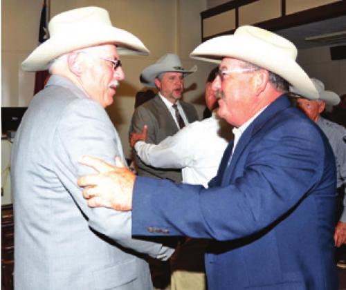 NEW BURLESON COUNTY Sheriff Gene Hermes is congratulated by Retired Chief Deputy Mike Brackman after the swearing in ceremony at the courthouse. -- Tribune photo by Roy Sanders