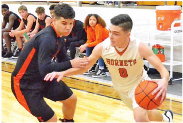 BOBBY LAROUAX DRIBBLES the ball past this Smithville defender on Friday, Jan. 17, in Caldwell. The Hornets won their district opener 60-38. -- Tribune photo by Roy Sanders