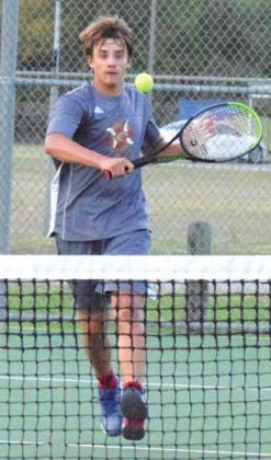 WAYLON CHAPMAN rushes to the net to return the ball during his boys’ singles match in Bastrop. -- Tribune photo by Denise Hornaday