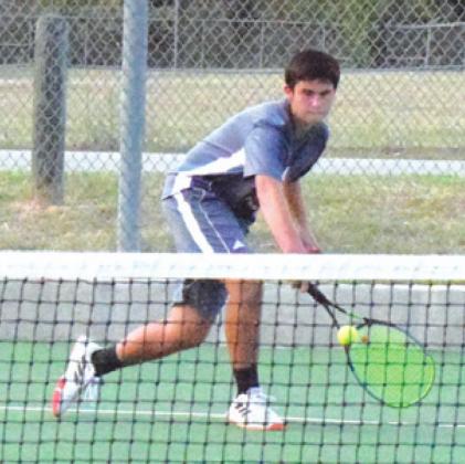 CONNOR HUGHSON reaches to backhand a hit from Caleb Cadena during their singles match. -- Tribune photo by Denise Hornaday