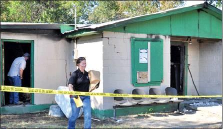 BURLESON COUNTY SHERIFF’S Investigators Tim Davis and Christine Labertew work at the scene of this arson off F.M. 166 in Tunis. A Somerville man was arrested on an arson charge.