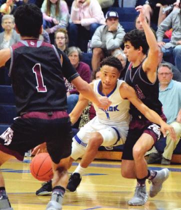 SNOOK&#x2019;S DRE&#x2019;RAUD ROGERS dribbles through two Iola defenders during the Bluejays&#x2019; home game against Iola Tuesday. Rogers had 10 points in Snook&#x2019;s 46-42 win. -- Tribune photo by Denise Hornaday