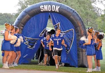 THE SNOOK FOOTBALL TEAM ENTERED the stage for Meet the Bluejays Monday night, Aug. 19, at the Snook City Park to the school’s fight song. Pictured are players Garrett Lero and David Davila. -- Tribune photo by Denise Hornaday