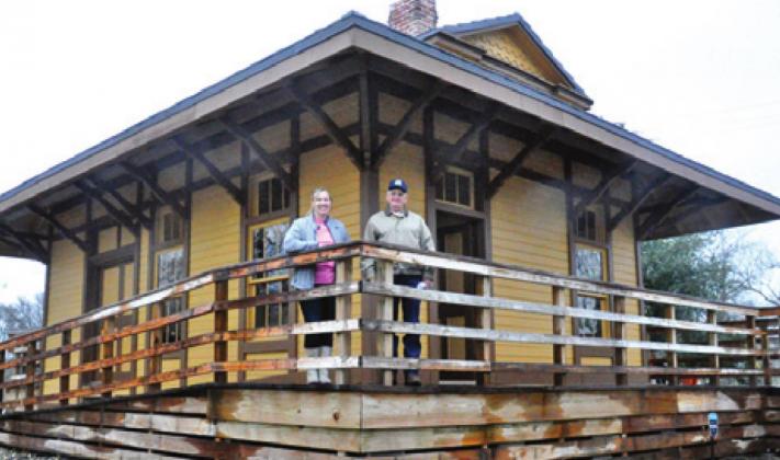 MARSHA KOCUREK AND Tommy Ryan stand at the front of the railroad depot in Deanville. -- Tribune photo by Roy Sanders
