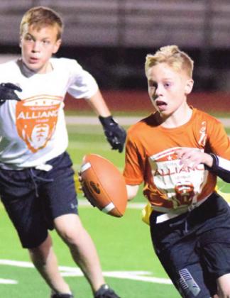 CALDWELL ORANGE’S Ty Langley runs with the ball with Logan Albright in pursuit during the Alliance Youth Football League’s Division D3 Super Bowl last Thursday at Hornet Stadium.