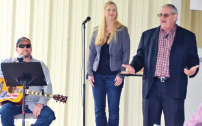 REV. CHARLES COLE, right, preaches as Kyle and Stacey Griesbach look on. The church’s “drive in” service was a success, allowing parishioners to still experience church services.