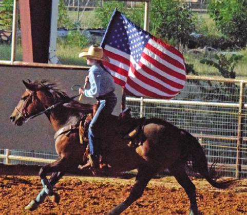 THE AMERICAN FLAG is carried around the arena to begin the annual Burleson County Youth Rodeo. --Tribune photo by Denise Hornaday