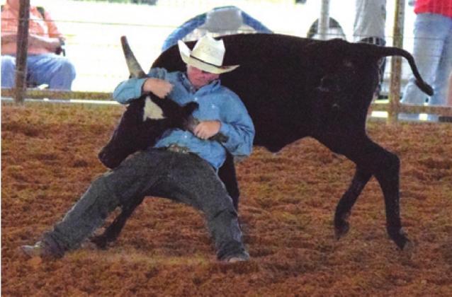 A STEER IS wrestled to the ground in the Chute Dogging event at the annual Burleson County Youth Rodeo in Caldwell last weekend at the Burleson County Fairgrounds. --Tribune photo by Denise Hornaday