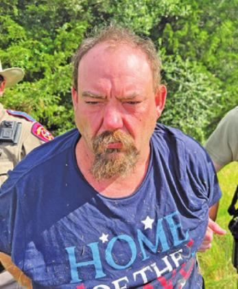 TODD WANGLER IS placed under arrest following the manhunt in the Chriesman area.