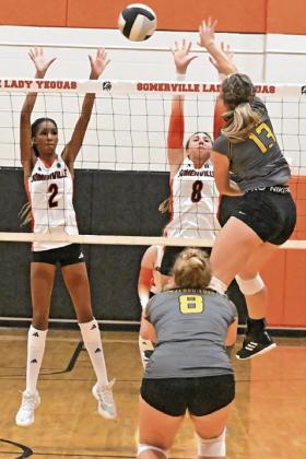 SOMERVILLE’S KARYS ELLIS and Abigail Richardson stretch to attempt to block the hit from a Rosebud-Lott player on Friday during the Lady Yeguas’ win over the Lady Cougars. Tribune photo by Denise Squier