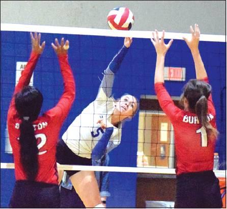 SNOOK’S KENZIE KMIEC hits the ball between Burton’s Azhane Graves and Alex Countouriotis during the Lady Jays’ win over Burton on Tuesday, Oct. 1. -- Tribune photo by Denise Hornaday