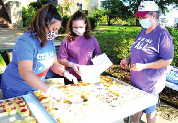AIMEE MARKERT SERVES these kolaches to Beth Campbell of Dime Box during the second Saturday celebration in downtown Caldwell.