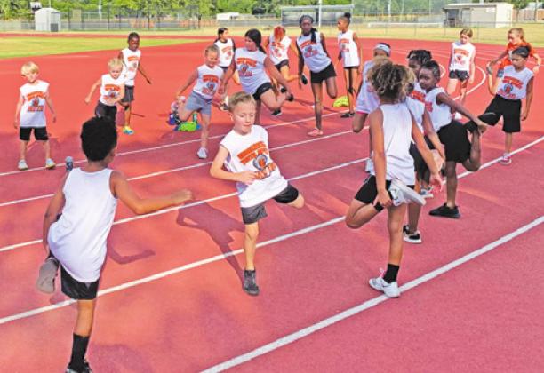 MEMBERS OF THE SOMERVILLE Youth Sports track team warm up before the track meet held in Somerville last Thursday, July 14.