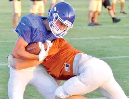 A CALDWELL HORNET makes a tackle last Friday against Robinson in Caldwell. The Hornets scrimmaged the Rockets and battled them to a tie in two live quarters. -- Tribune photo by Roy Sanders