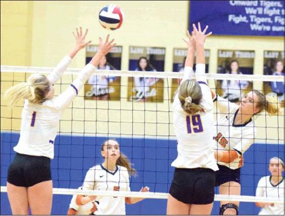CALDWELL’S ELIZABETH SEE HITS the ball over Liberty Hill’s Ashley Nelson and Ailie Hair during Friday night’s area match in Rockdale. See led the Lady Hornets in kills with 19 and scored the final point in the fifth set to win the match. -- Tribune photo by Denise Hornaday