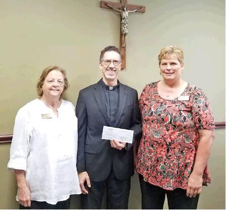 Jean Ribar of Marak, left, and Donna Janda of Hostyn, right, posed for a photo with Rev. Tim Nolt, Vicar for Priests at the Diocese of Austin, as they presented a check for $2,904. It was donated to the Austin Diocese for the education of priests from local KJZT societies, including Caldwell and Frenstat.