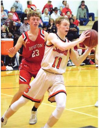 GARRISON BALLARD gets around a Burton defender at the baseline to pass the ball to a teammate during Friday night’s home game.